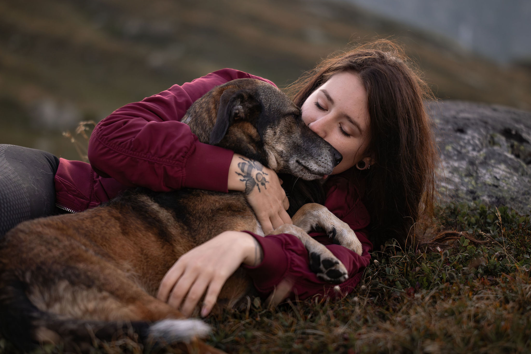 Eine Frau kuschelt mit ihrem Hund