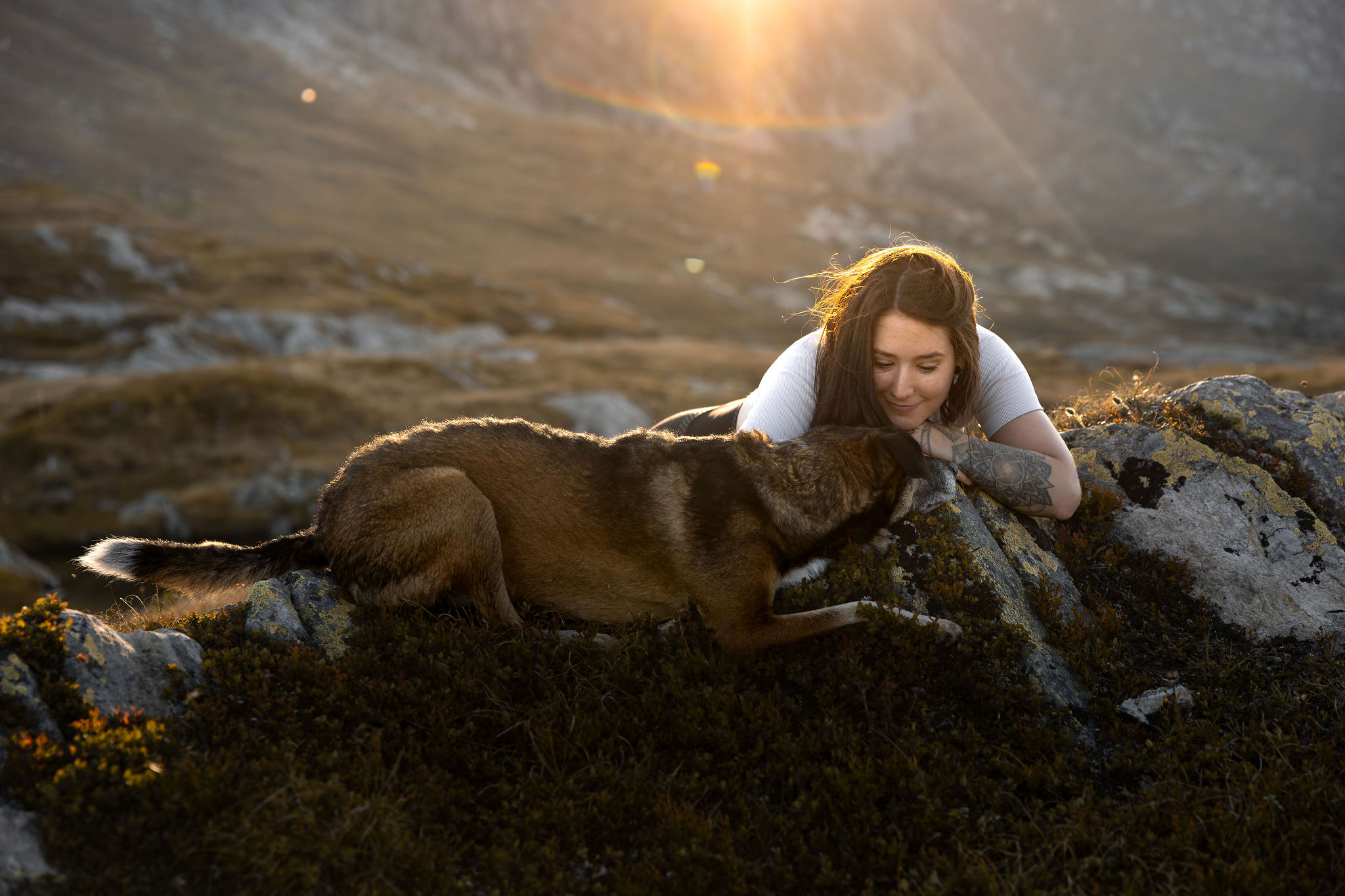 Ein Hund kuschelt nahe an seinen Menschen in den Schweizer Bergen
